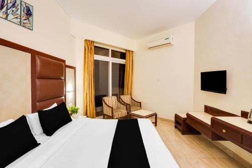 a hotel room with a bed and a tv at Super Townhouse Oak Silver City Chowk Formerly HW Residency in Dehradun