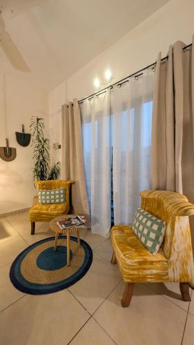 a living room with two chairs and a table at La Maison de Canelya in Cotonou