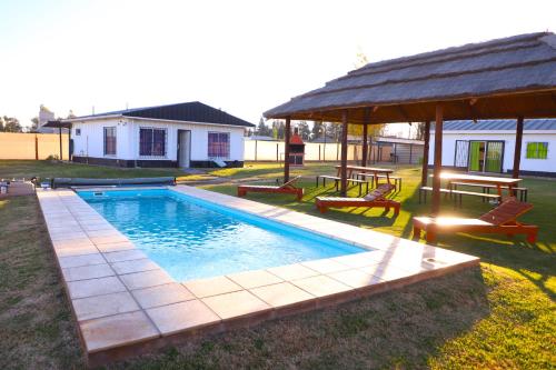 a swimming pool in a yard with a gazebo at Cabañas Willy Azul con pileta climatizada y parque en Mendoza in Las Compuertas