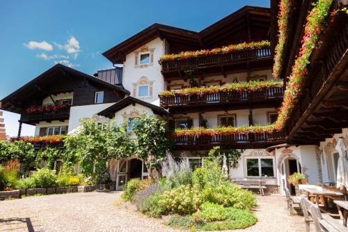a building with flower boxes on the side of it at Bio & BikeHotel Steineggerhof in Collepietra