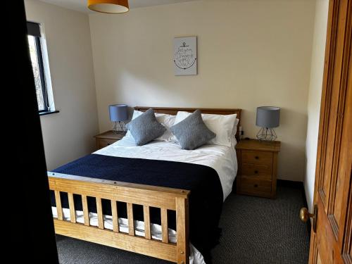 a bedroom with a bed with two night stands and two lamps at Northfield Holiday Park in Borth