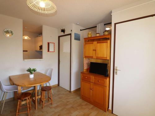 - une cuisine et une salle à manger avec une table et un four micro-ondes dans l'établissement Appartement 2P Cabine proche plage avec garage, lumineux et bien situé au Grau-du-Roi - FR-1-307-136, au Grau-du-Roi