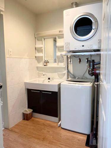 a small bathroom with a sink and a mirror at アラハブルーリゾート in Chatan