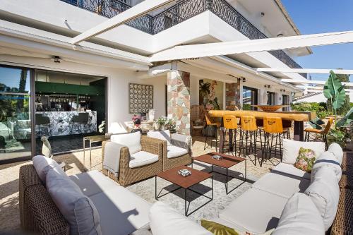 an outdoor patio with couches and a bar at HOTEL LA QUIETUDE in Les Issambres