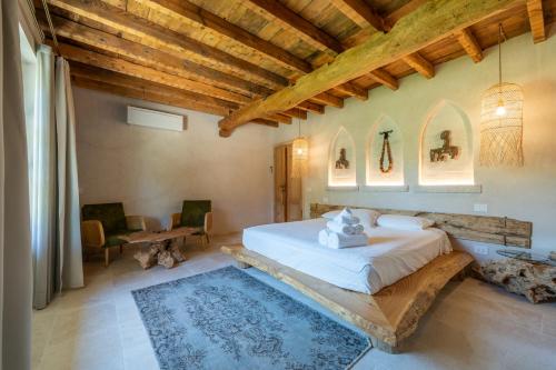 a bedroom with a large bed and a wooden ceiling at Villa Mario Resort in Salò