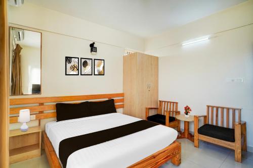 um quarto com uma cama e duas cadeiras em Super Collection O Kalyan Nagar Formerly Prime Square em Bangalore