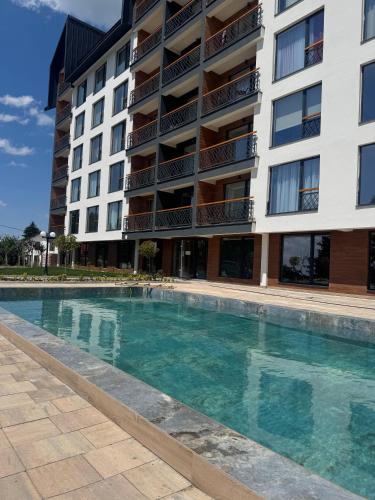 a swimming pool in front of a building at Fashion Residence Hill in Kopaonik