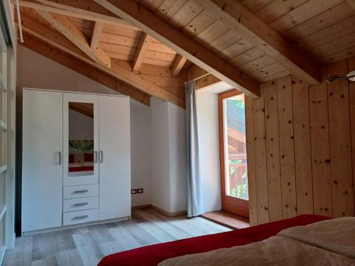 a bedroom with a bed and a large window at Bambù in Caldonazzo