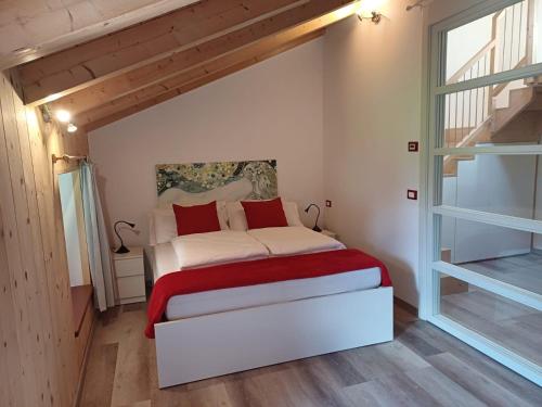 a bedroom with a white bed with red pillows at Bambù in Caldonazzo
