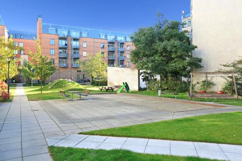 a park with benches in front of a building at CPH Lux Apartments KH in Copenhagen