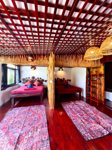 a room with two beds with people laying on them at Mai Pen Rai Bungalows in Than Sadet Beach