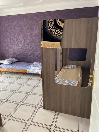 a room with two bunk beds and a tiled floor at La belle vue in Bologuine Ibnou Ziri