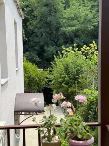 a balcony with two chairs and potted plants at Guest House at the park in Kutaisi