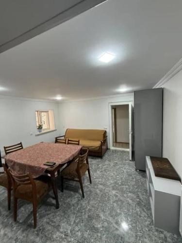 a room with a table and chairs and a couch at Guest House at the park in Kutaisi