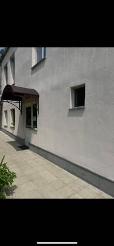 a white building with an awning on the side of it at Guest House at the park in Kutaisi