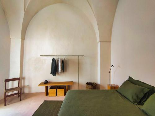 a bedroom with a green bed and a table at Casa Micocci di Casa Camilla Journey in Depressa