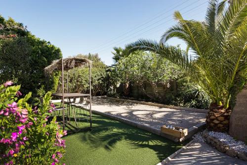 a garden with a swing and a swimming pool at HOTEL LA QUIETUDE in Les Issambres