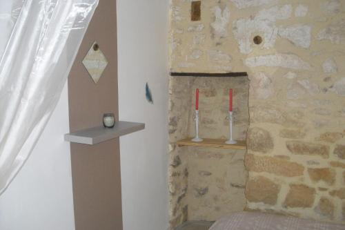 Habitación con una pared de piedra con velas rojas en La Bergerie Lou Mas Li Pitchoun, en Gordes