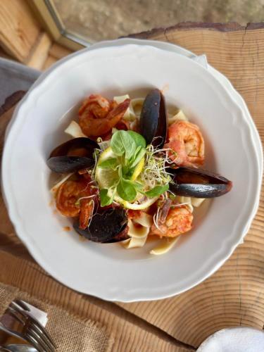 a bowl of food with shrimp and mussels on a table at domki z dostępem do SPA i restauracji in Łapsze Niżne