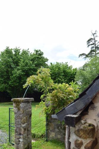 a stone building with a roof and some bushes at Ô Retrouvail ' in Cublac