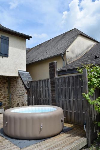 a hot tub on a deck in front of a house at Ô Retrouvail ' in Cublac