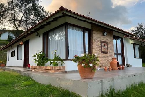 a small house with plants in front of it at Casa de montaña con vista, BBQ y wifi confiable in Subachoque