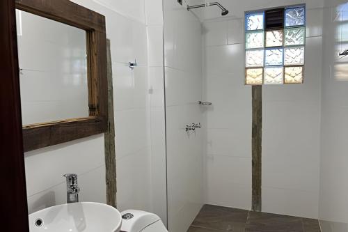 a white bathroom with a sink and a mirror at Casa de montaña con vista, BBQ y wifi confiable in Subachoque