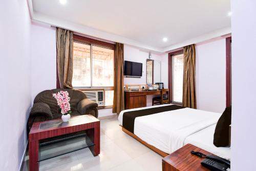 a hotel room with a bed and a tv at Super Collection O Shanti Bhawan Bank More Formerly Madhulika in Dhanbād