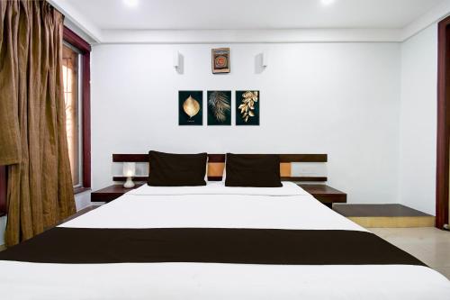 a bedroom with a large white bed with black pillows at Super Collection O Shanti Bhawan Bank More Formerly Madhulika in Dhanbād