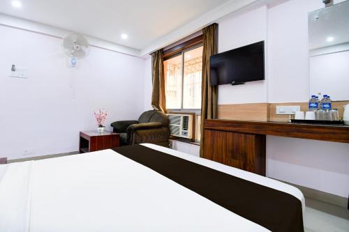 a hotel room with a bed and a flat screen tv at Super Collection O Shanti Bhawan Bank More Formerly Madhulika in Dhanbād
