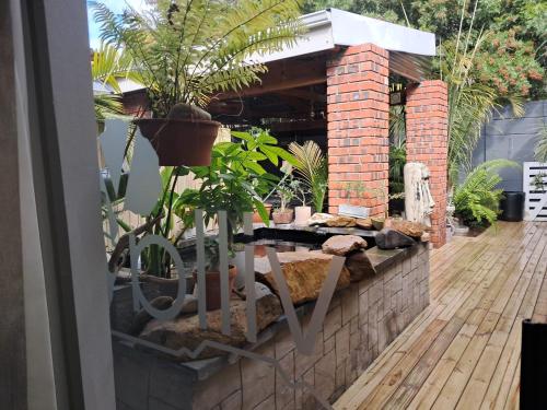 a patio with a table with plants on it at Villa Mariss Guesthouse in Kraaifontein