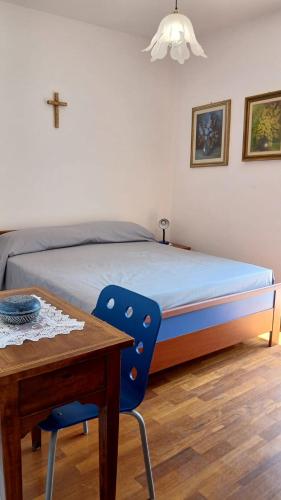 a bedroom with a bed and a table and a cross on the wall at Casa storica di Sant'Andrea by Italita in Calamandrana