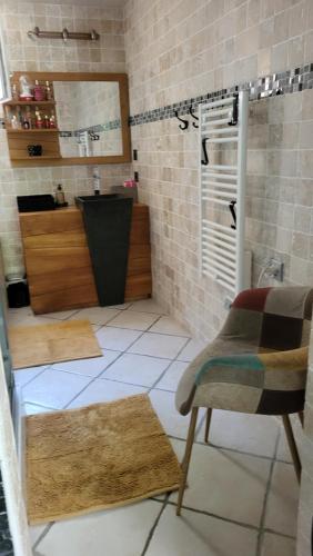 a bathroom with a chair and a sink in a room at Havre de Paix in Nîmes