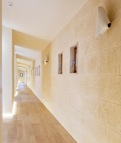 a long hallway with white walls and wooden floors at Casal Santa Eulalia in Can Picafort
