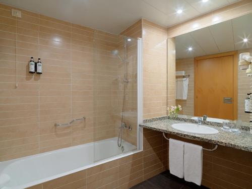 a bathroom with a shower and a sink and a tub at Ponient Vila Centric by PortAventura World in Vila-seca