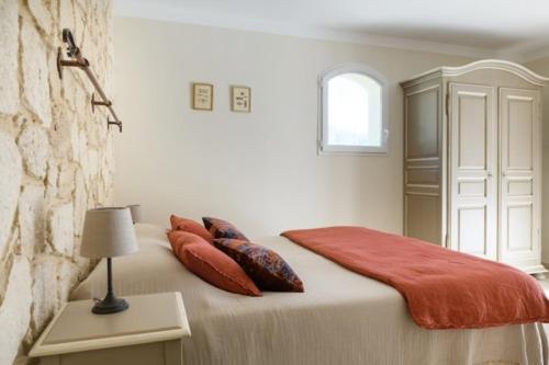 a bedroom with a bed with pillows and a window at Le Mas du Grand Chêne - Chambres & Roulotte in Nyons