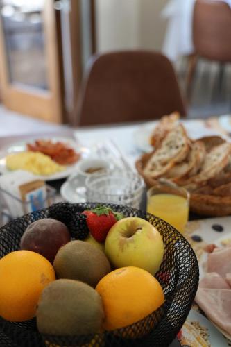 a table with a bowl of fruit on a table at Hotel Il Portico by LVG Hotel Collection in Cannobio