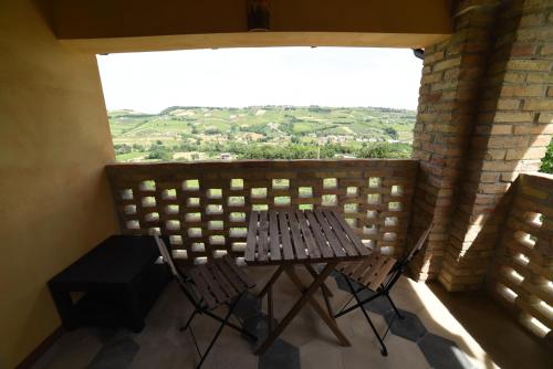 a table and chairs on a balcony with a large window at Agriturismo " La Valle degli Ulivi" in Vacri
