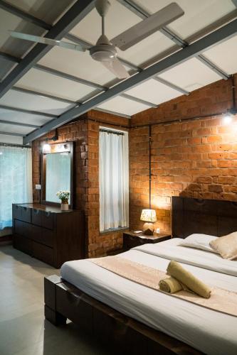 a bedroom with a large bed and a brick wall at The Island Sanctuary - A Village Secret in Chorao