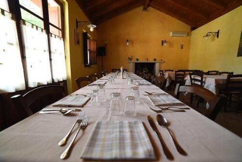 a long table with plates and silverware in a room at Agriturismo " La Valle degli Ulivi" in Vacri