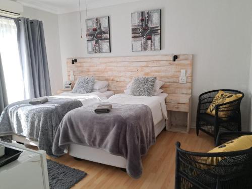 a bedroom with two beds with blankets on them at Villa Mariss Guesthouse in Kraaifontein