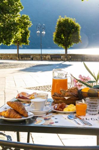 a table with plates of food and drinks on it at Hotel Il Portico by LVG Hotel Collection in Cannobio