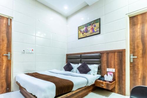 a bedroom with a bed and a tv on the wall at Jasneet Homestay in Amritsar