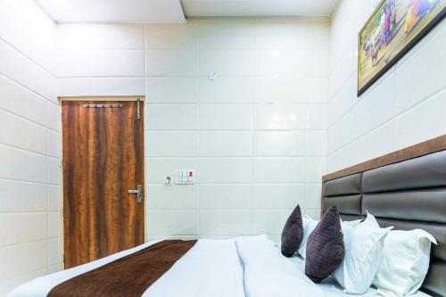 a bedroom with a bed and a wooden door at Jasneet Homestay in Amritsar