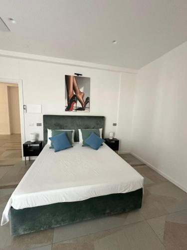 a bedroom with a large white bed with blue pillows at Crazi Suites in Nola