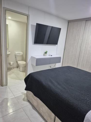a bedroom with a bed and a flat screen tv at Moderno y cómodo apartamento in Cúcuta