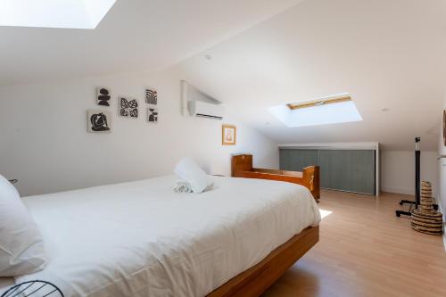 a bedroom with a large white bed and a skylight at Orcines -Appt Lumineux & calme - Vulcania à 10 min in Orcines