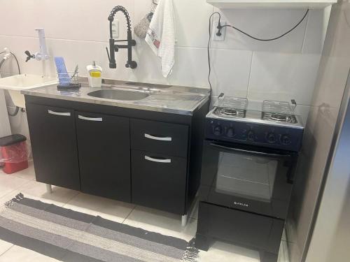 a small kitchen with a stove and a sink at BORA BORA RESIDENCE in Joinville