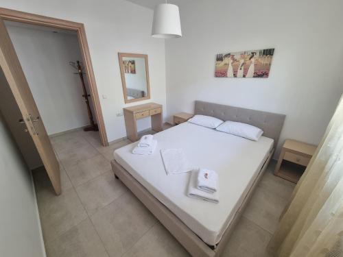 a small bedroom with a white bed and a mirror at On The Rocks in Theologos