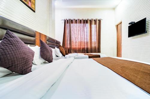 a bedroom with a large white bed with purple pillows at Jasneet Homestay in Amritsar